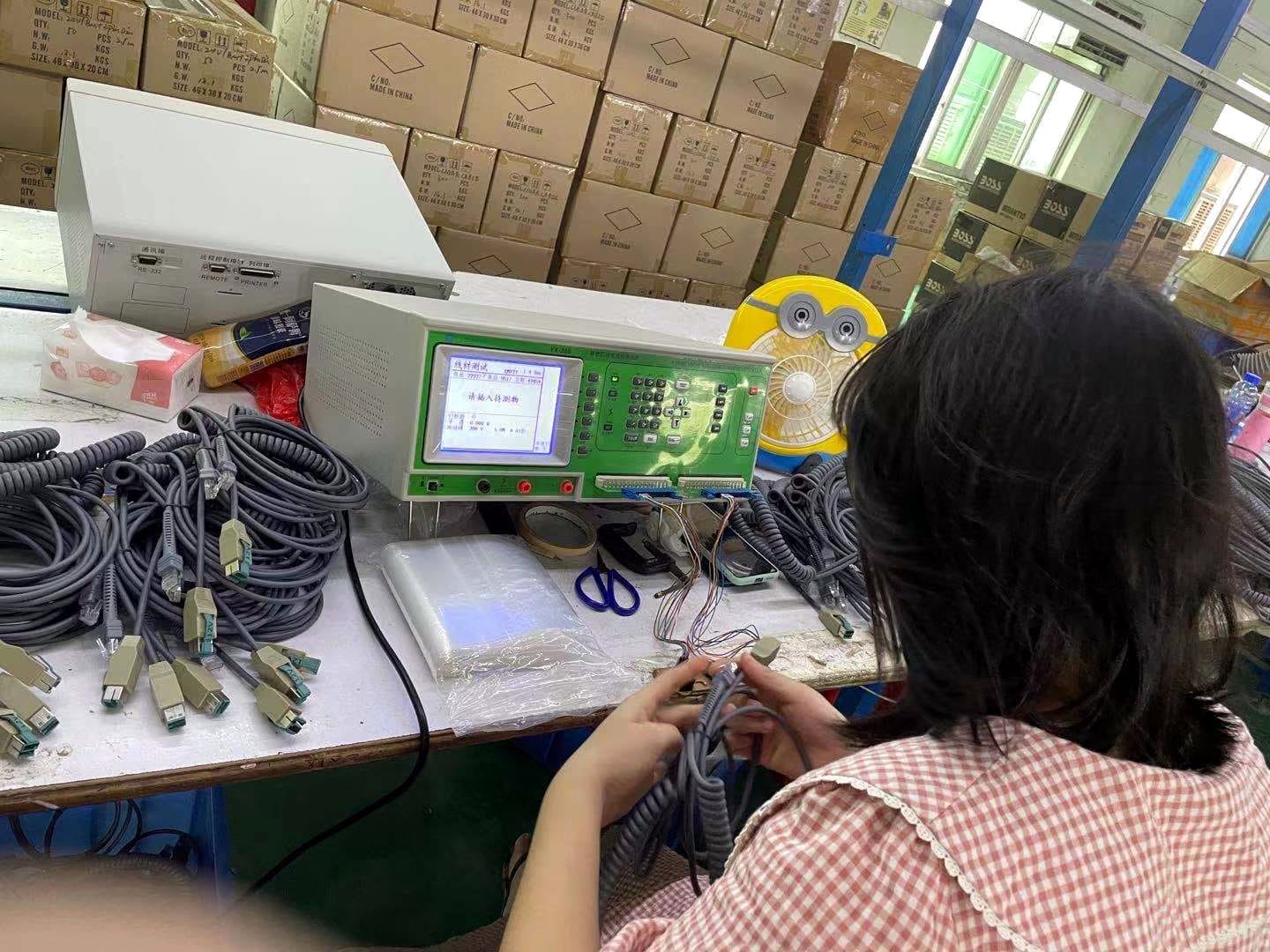 Operator running electrical verification on cable assemblies